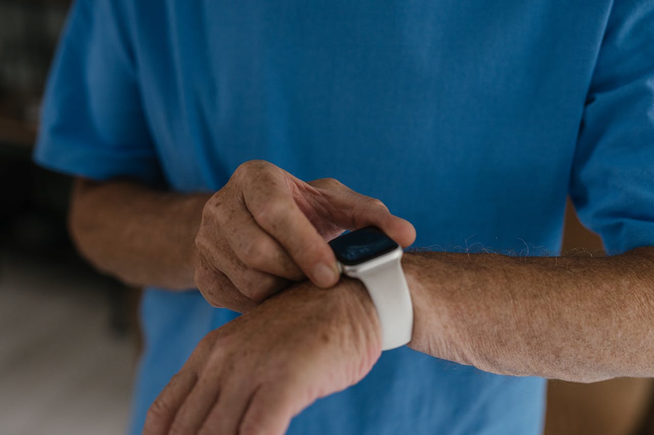 Close-up of a man's hands interacting with a smartwatch on his wrist.